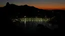 Patung Kristus Penebus yang berada diatas gunung Corcovado terlihat saat matahari terbenam di pantai Botafogo, Rio de Janeiro, Brasil, 16 Juni 2016. (REUTERS/Ricardo Moraes)