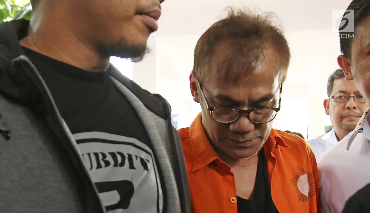 Tersangka Tio Pakusadewo digiring polisi jelang jumpa pers terkait kepemilikan narkoba jenis sabu di Dit Narkoba Polda Metro Jaya, Jakarta, Jumat (22/12). Tio ditangkap kediamannya di kawasan Ampera, Jakarta Selatan. (Liputan6.com/Herman Zakharia)
