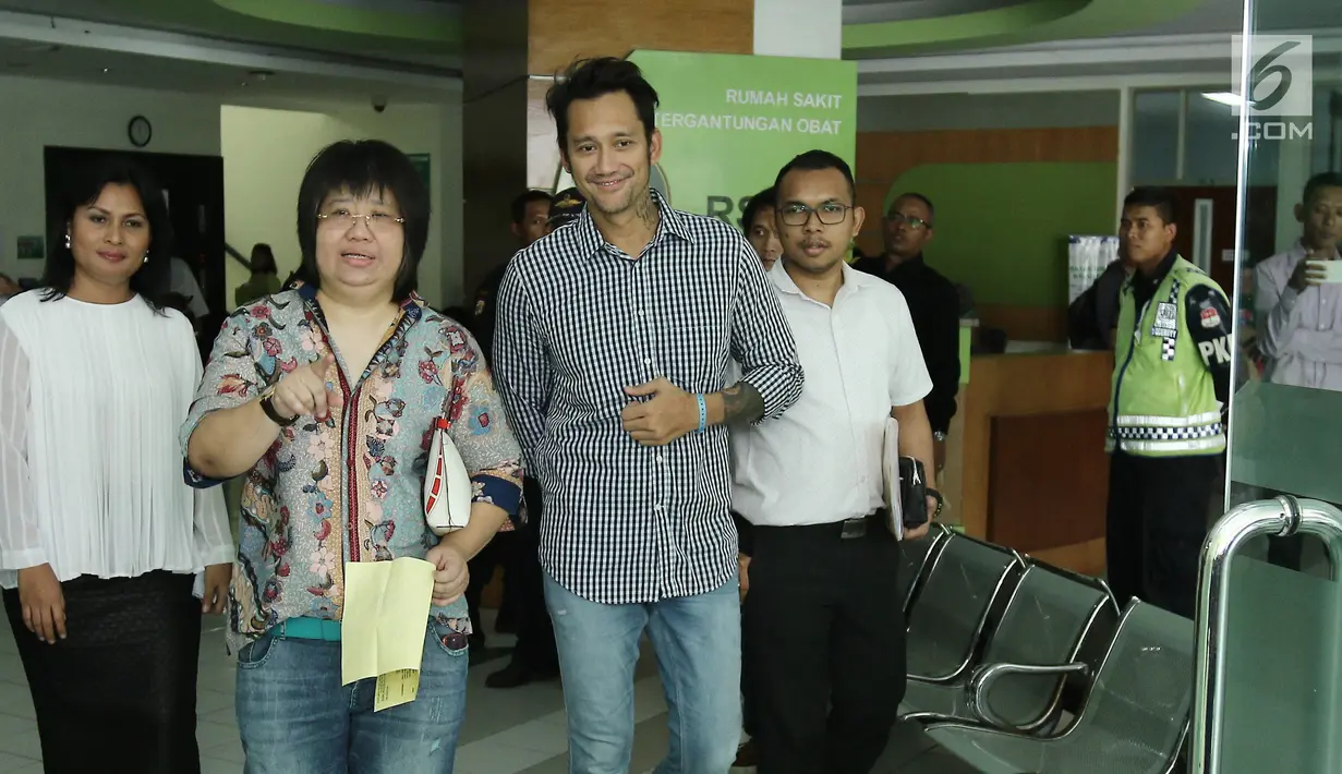 Aktor Tora Sudiro  didampingi kuasa hukum keluar dari Rumah Sakit Ketergantungan Obat (RSKO) Cibubur, Jakarta, Senin (14/8). Tora Sudiro tersenyum bahagia setelah pengajuan penangguhan penahanannya dikabulkan oleh penyidik. (Liputan6.com/Herman Zakharia)