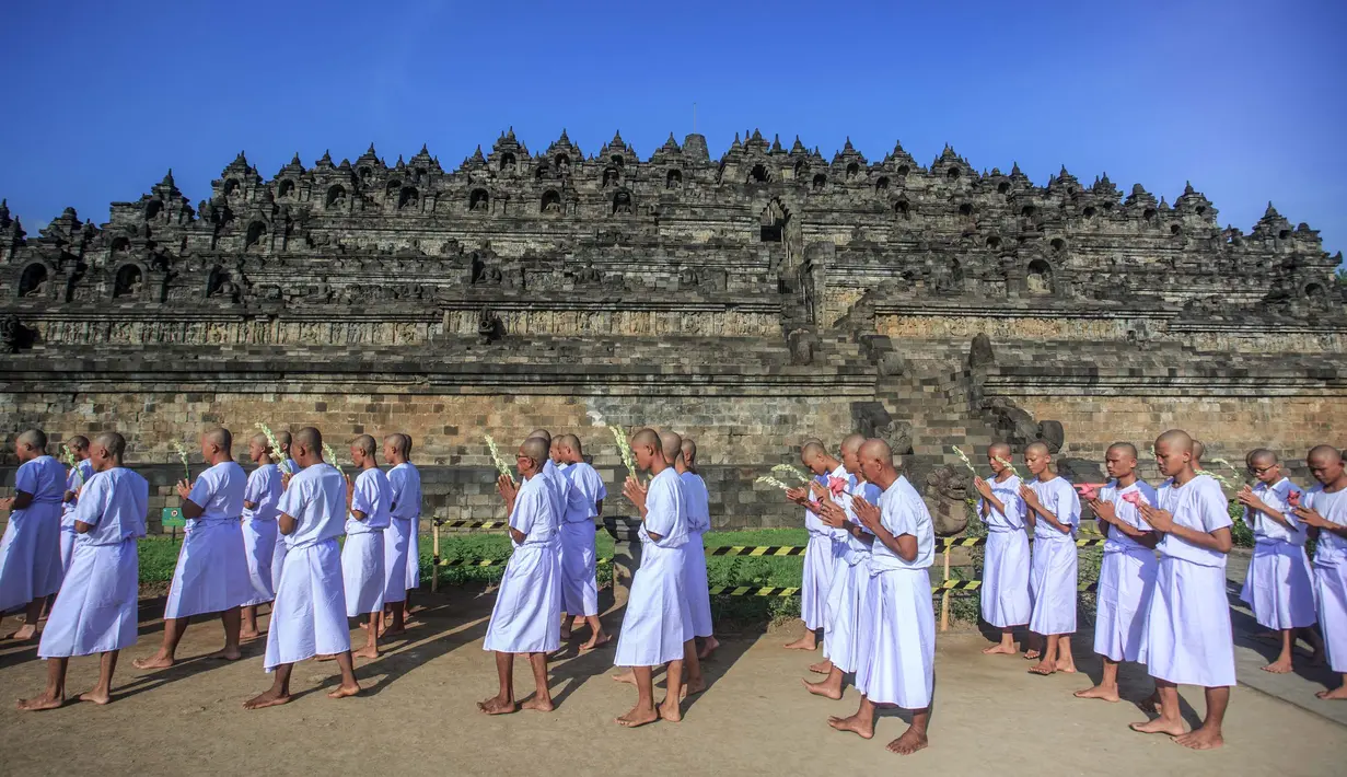 Para calon biksu bermeditasi sambil berjalan tanpa alas kaki dalam ritual 'Pabbaja Samanera', di kawasan Candi Borobudur, Magelang, Jawa Tengah, 19 Desember 2023. (DEVI RAHMAN/AFP)
