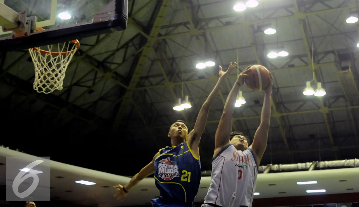 Pemain Satria Muda Pertamina, M Rizal Falconi (kiri) menahan serangan penyerang Stadium, Valentino Wuwungan pada laga Perbasi Cup 2016 di GOR Soemantri Brodjonegoro, Jakarta, Selasa (25/10). Satria menang telak 73-59. (Liputan6.com/Helmi Fithriansyah)
