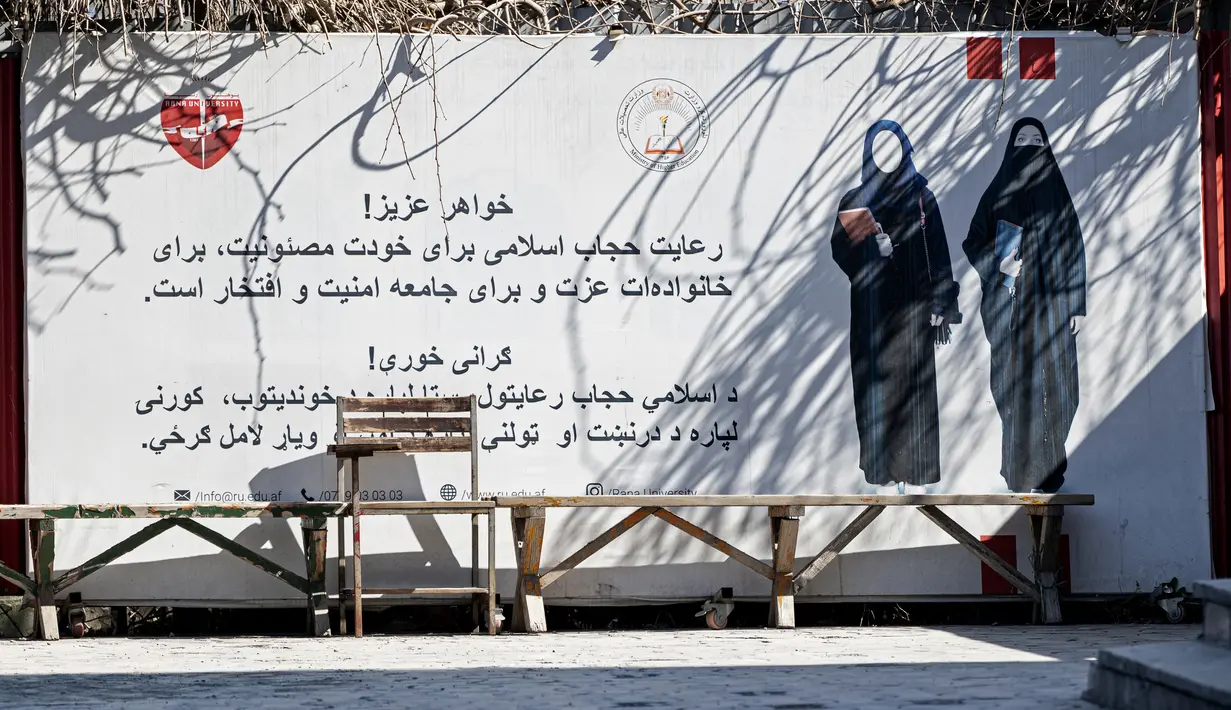 Spanduk yang memerintahkan perempuan untuk menutup diri dengan Hijab digambarkan di sebuah universitas swasta setelah kampus dibuka kembali di Kabul, Afghanistan, Senin (6/3/2023). Meski sempat menyatakan tak akan melakukan pelarangan pada perempuan untuk menempuh pendidikan, faktanya berbagai bentuk tekanan dan pelarangan pada perempuan yang ingin berkuliah terus terjadi. (Wakil KOHSAR / AFP)