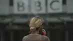 Seorang perempuan berjalan di luar Markas Besar BBC di London, Inggris, Selasa (11/7/2023). Detektif Inggris bertemu dengan perwakilan BBC pada hari Senin atas tuduhan bahwa seorang presenter terkemuka membayar seorang remaja untuk foto-foto eksplisit secara seksual. (AP Photo/Kin Cheung)
