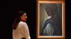 Karyawan rumah lelang Bonhams berpose dekat lukisan seorang putri Nigeria bernama Tutu di London, Inggris pada 7 Februari 2018. Lukisan yang kerap disebut ‘Mona Lisa dari Afrika’ itu terjual dalam sebuah lelang pada 28 Februari 2018. (BEN STANSALL/AFP)