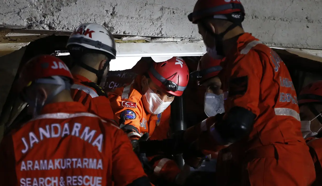 Anggota layanan penyelamatan mencari orang-orang yang selamat di puing-puing bangunan yang runtuh di Izmir, Turki, Sabtu (31/10/2020). Gempa bumi yang kuat melanda pada hari Jumat di Laut Aegea antara pantai Turki dan pulau Samos di Yunani, menewaskan beberapa orang. (AP Photo/Emrah Gurel)