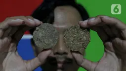 Salah satu pemuda perajin menunjukkan hasil olahan eceng gondok di kawasan Plaju, Palembang, Sumatra Selatan, Senin (26/5/2025). (Liputan6.com/Herman Zakharia)