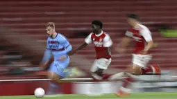 Penyerang West Ham,  Jarrod Bowen membawa bola dari kejaran gelandang Arsenal, Bukayo Saka pada pertandingan lanjutan Liga Inggris di Stadion Emirates di London, Inggris, Sabtu (19/9/2020). Arsenal menang tipis 2-1 atas West Ham. (AP Photo/Ian Walton, Pool)