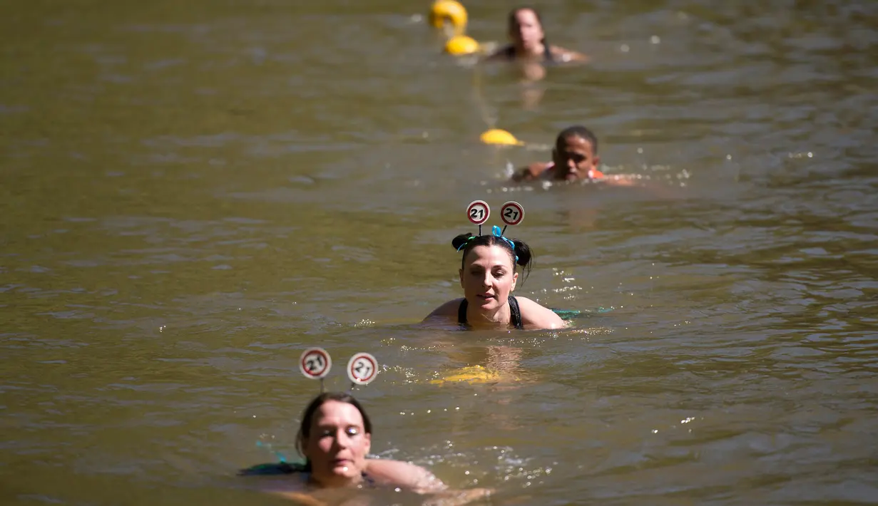 Peserta berenang di bendungan selama lomba lari Strongman Run di kota Paarl, Afrika Selatan, 13 Oktober 2018. Karena peserta yang semakin bertambah, Strongman Run kini diadakan beberapa kali setahun di berbagai negara di Eropa. (RODGER BOSCH/AFP)