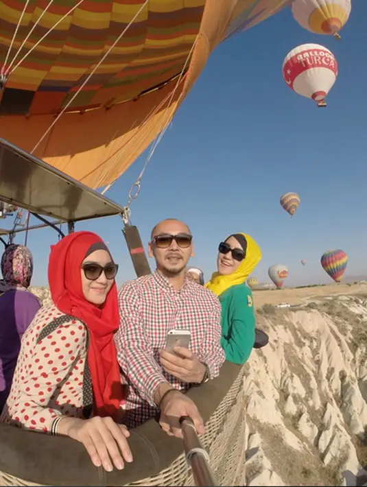 Citra Kirana terbang mengudara dengan balon udara di Cappadocia, Turki. Ia dan kerabatnya tampak menikmati suasana di ketinggian pasir Timur Tengah tersebut. (via instagram/@citraciki)