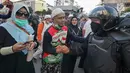 Peserta aksi bersalaman dengan Polisi dari kesatuan Brimob saat gelar doa bersama di depan kantor Bawaslu, Jakarta, Jumat (24/5/2019). Mereka datang untuk mendoakan para demonstran yang meninggal saat aksi 21-22 Mei, pasca hasil penghitungan suara Pemilu 2019. (Liputan6.com/Herman Zakharia)