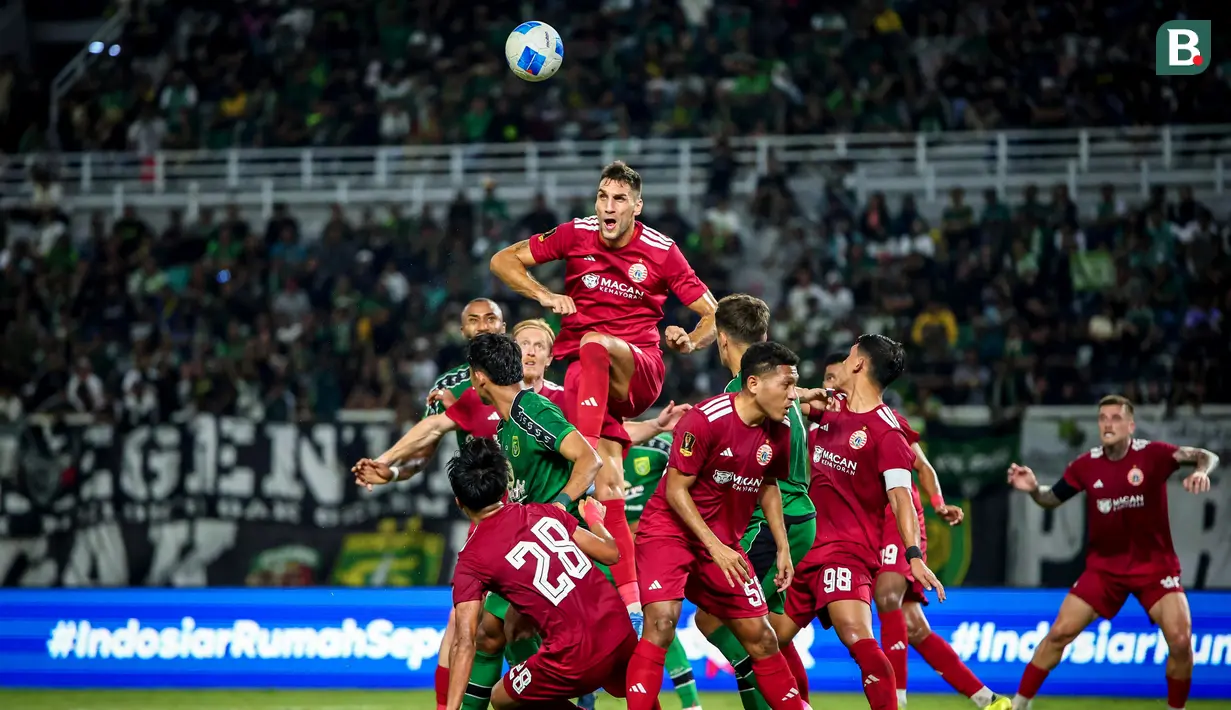 Pemain Persija Jakarta, Denis Kolinger, berusaha menyambut bola lambung di tengah kawalan para pemain Persebaya Surabaya pada laga Grup B Piala Presiden 2026 di Stadion Gelora Bung Tomo, Surabaya, Minggu (26/7/2026) malam. Persija harus mengakui keunggulan tuan rumah dengan skor 0-1 setelah gol bunuh diri Radovan Pankov pada menit ke-64 menjadi pembeda dalam pertandingan tersebut. (Bola.com/Wahyu Pratama)