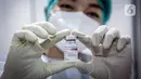 Petugas medis menunjukkan vaksin COVID-19 Astrazeneca saat vaksinasi pekerja ritel di GOR Tanjung Duren, Jakarta Barat, Senin (24/5/2021). Berdasarkan data Kementerian Kesehatan hingga 23 Mei 2021, sebanyak 14.890.933 orang telah menerima vaksin COVID-19 dosis pertama. (Liputan6.com/Faizal Fanani)