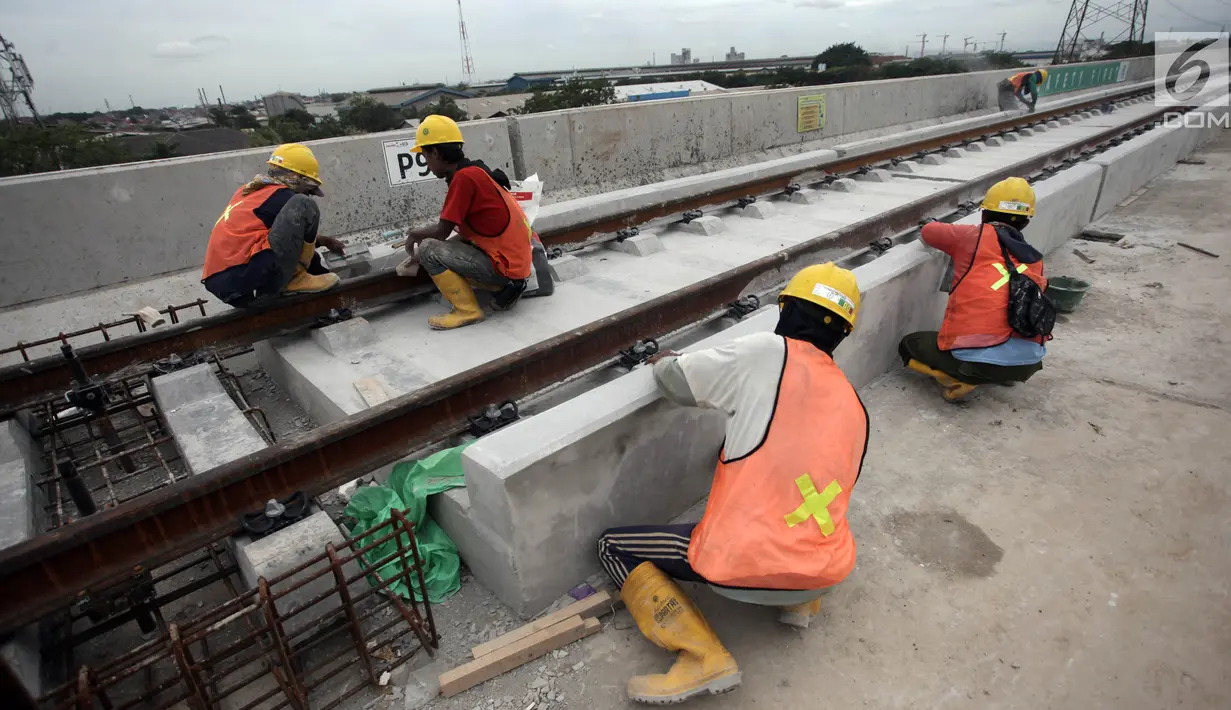 Pekerja merapikan bantalan rel di Depo LRT, Kelapa Gading, Jakarta Utara, Kamis (25/1). Satu gerbong kereta LRT mampu menampung 135 orang. (Liputan6.com/Arya Manggala)