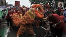 Warga memberikan angpau ke barongsai saat perayaan Cap Go Meh Tahun Baru Imlek 2571 di Jatinegara, Jakarta, Minggu (9/2/2020). Meski hujan, perayaan Cap Go Meh berlangsung meriah dengan atraksi barongsai dan liong serta arakan dewa-dewa mengelilingi kawasan Jatinegara. (merdeka.com/Iqbal S Nugroho)