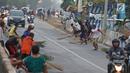 Warga berebut uang yang dilemparkan pengguna jalan menggunakan sapu di Jembatan Sewo, Indramayu, Jawa Barat, Senin (3/6/2019). Kehadiran pencari sedekah tersebut biasanya kian bertambah banyak saat menjelang arus mudik Lebaran. (Liputan6.com/Herman Zakharia)
