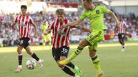 Christian Eriksen (kanan) melepaskan tembakan yang diblok oleh pemain Brentford.&nbsp;Manchester United dibantai 0-4 di Gtech Community Stadium dalam lanjutan Liga Inggris 2022/2023, Sabtu (13/8/2022). (AP Photo/Ian Walton)