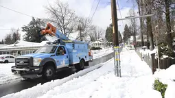 Pekerja Pacific Gas & Electric mulai memeriksa jalur di City of Grass Valley, California, Selasa (28/12/2021). Salju menyebabkan penutupan dan memaksa orang untuk mencari perlindungan di tempat penampungan darurat yang memanas. (Elias Funez/The Union via AP)