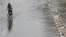 Warga berusaha menerobos banjir yang merendam Jalan Panjang, Jakarta Barat, Jumat (26/2). Hujan yang mengguyur wilayah Jakarta membuat sejumlah titik terendam banjir dengan ketinggian sekitar 20 cm hingga 1 meter. (Liputan6.com/ Immanuel Antonius)