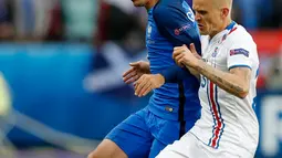 Bek Islandia, Ari Skulason (kanan) berebut bola dengan gelandang Prancis, Antoine Griezmann pada perempat final Piala Eropa di Stade Velodrome, Perancis, (3/7). Prancis akan bertemu Jerman pada semifinal Euro 2016. (REUTERS/Carl Recine)