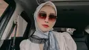 Tampil modis dengan mengenakan hijab bermotif yang disimpul di bagian samping. (Instagram.com/melodyprima).