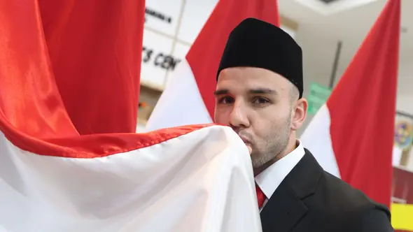 Calvin Verdonk mencium bendera Merah-Putih setelah pengambilan sumpah untuk menjadi Warga Negara Indonesia (WNI) di Kantor Kanwil Kemenkumham DKI Jakarta, Selasa (4/6/2024) malam WIB. (Bola.com/Dok. PSSI)