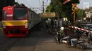 Kereta api melintas di kawasan Lenteng Agung, Jakarta, Kamis (14/3). Untuk mengurai kemacetan, Pemprov DKI Jakarta akan membangun jalan layang (fly over) berbentuk tapal kuda di perlintasan tersebut. (Liputan6.com/Immanuel Antonius)