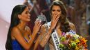 Miss Universe 2015, Pia Wurtzbach (kiri) bersiap memasangkan mahkota Miss Universe kepada Miss Prancis, Iris Mittenaere di Mall of Asia Arena, Manila, Filipina, Senin (30/1). Iris Mittenaere dinobatkan menjadi Miss Universe 2016. (AP Photo/Bullit Marquez)