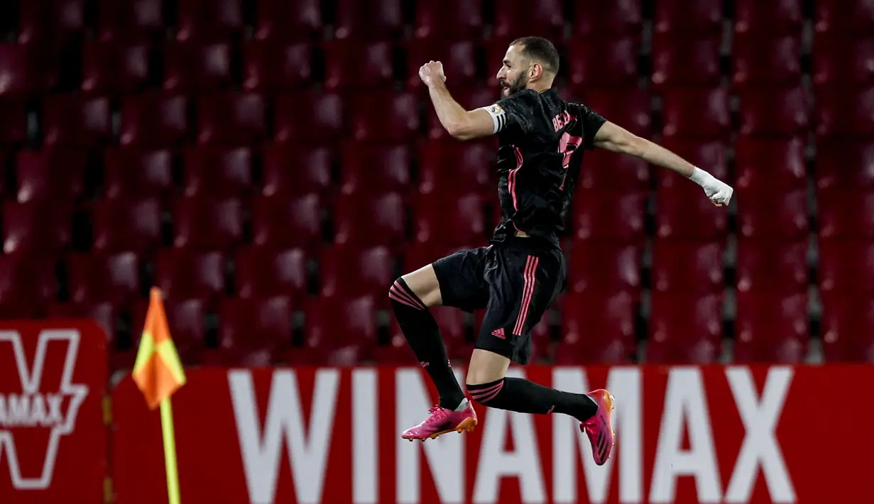 Striker Real Madrid, Karim Benzema melakukan selebrasi usai mencetak gol keempat timnya ke gawang Granada dalam laga lanjutan Liga Spanyol 2020/2021 pekan ke-36 di Los Carmenes Stadium, Granada, Kamis (13/5/2021). Real Madrid menang 4-1 atas Granada. (AP/Fermin Rodriguez)