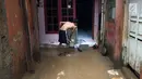Seorang warga membersihkan lumpur sisa banjir yang menggenangi rumahnya di kawasan Rawajati, Jakarta Selatan, Selasa (6/2). Banjir yang mulai surut dimanfaatkan warga untuk membersihkan lumpur. (Liputan6.com/Immanuel Antonius)