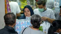 Pedagang melayani pembeli di salah satu toko penjualan masker di Pasar Pramuka, Jakarta Timur, Rabu (4/3/2020). Polda Metro Jaya menggelar sidak di Pasar Pramuka untuk menyikapi lonjakan harga dan kelangkaan masker di pasaran terkait virus corona atau COVID-19. (merdeka.com/Imam Buhori)