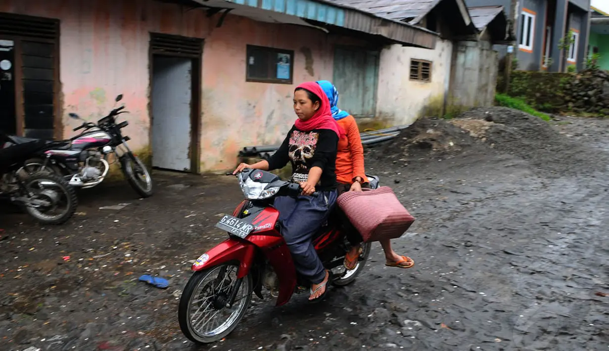 Dua orang warga desa kawasan zona merah Gunung Slamet tampak mengendarai motor untuk pergi ke pasar. (Liputan6.com/Andrian M Tunay)