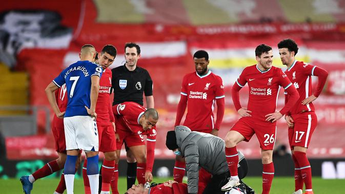 Kapten Liverpool, Jordan Henderson, harus mendapatkan perawatan hingga akhirnya harus meninggalkan lapangan lebih cepat saat memperkuat The Reds menghadapi Everton pada pekan ke-25 Premier League, Minggu (21/2/2021) dini hari WIB. Liverpool kalah 0-2 dalam laga ini. (LAURENCE GRIFFITHS / POOL / AFP)