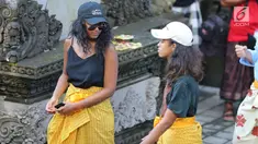 Dua putri Presiden ke-44 AS Barack Obama, Malia dan Sasha, mengunjungi Pura Tirta Empul, Tampaksiring, Gianyar, Bali, Selasa (27/6). Di pura bersejarah tersebut kedua putri Obama kompak mengenakan sarung warna kuning. (Liputan6.com/Immanuel Antonius)