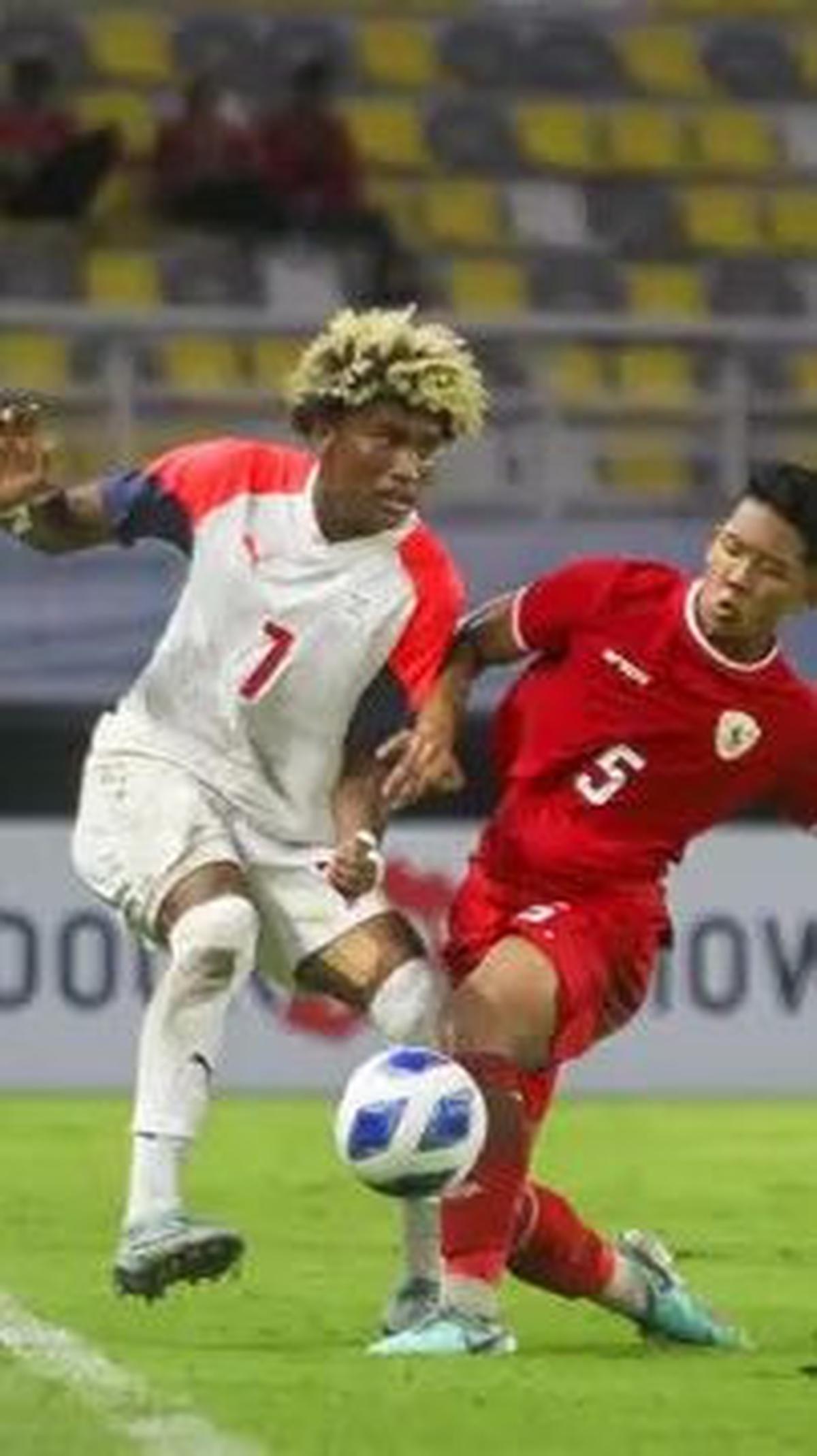 Aksi pemain Timnas Indonesia U-19, Muhammad Alfharezzi Buffon (tengah) berebut bola dengan pemain Filipina U-19, Otu Banatao Otu. (Bola.com/Aditya Wany)