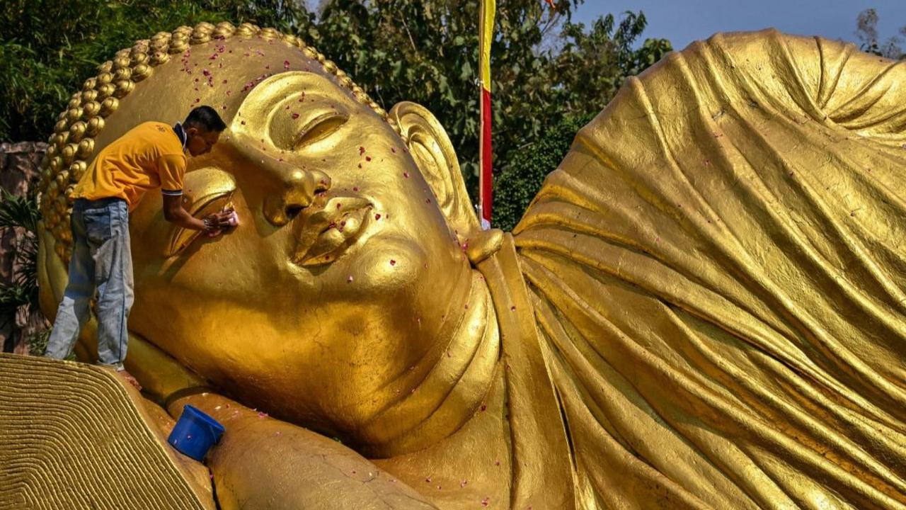 Pengurus memandikan patung Buddha Maha Paranibbana, yang biasa disebut Buddha Tidur, di&nbsp;Maha Vihara Mojopahit, Mojokerto, Jawa Timur, pada Rabu (16/5/2024). Pembersihan patung Buddha Tidur ini dilakukan menjelang perayaan Hari Raya Waisak, pada 23 Me