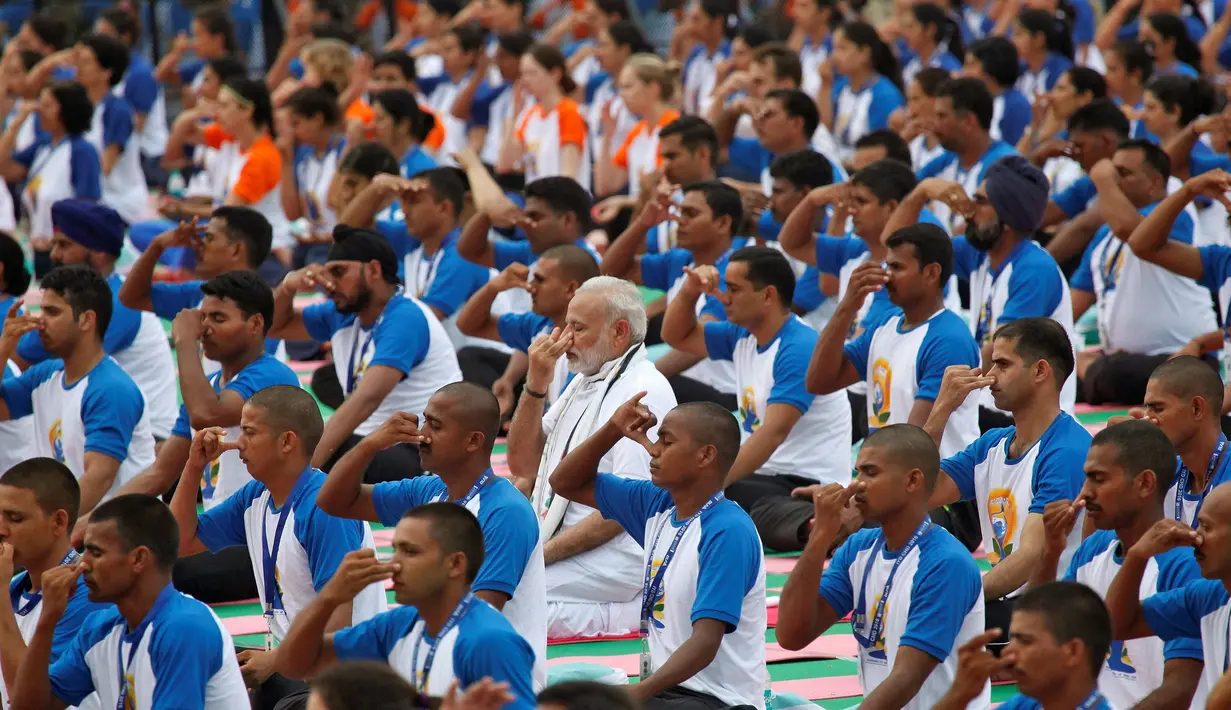 Perdana Menteri India Narendra Modi (tengah) melakukan gerakan Yoga bersama warga lainnya di Chandigarh , India , (21/6). Sejumlah negara di dunia sedang merayakan Hari Yoga Dunia yang jatuh pada tanggal 21 Juni. (REUTERS / Ajay Verma)