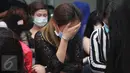 Seorang perempuan WNA menutup wajahnya saat diamankan di Kantor Imigrasi Kelas I Khusus Jakarta Barat, Sabtu (7/1). Petugas imigrasi berhasil mengamankan 20 Paspor, telepon genggam dan alat kontrasepsi. (Liputan6.com/Johan Tallo)