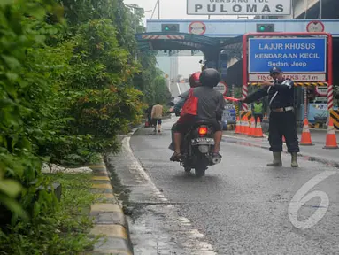 Hujan yang turun sejak Minggu (8/2) lalu mengakibatkan banjir di kawasan jalan Yos Sudarso, Jakarta. Sejumlah pengendara sepeda motor diperbolehkan melintasi jalan tol Wiyoto Wiyono, Jakarta, Senin (10/2/2015). (Liputan6.com/Herman Zakharia)