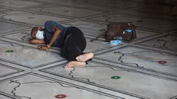 Seorang penjual masker beristirahat di lantai Masjid Jama yang dibuka kembali setelah pemerintah melonggarkan lockdown di kawasan Kota Tua Delhi, Selasa (7/7/2020). India pada 6 Juli menjadi negara dengan jumlah virus corona tertinggi ketiga di dunia. (Photo by XAVIER GALIANA / AFP)