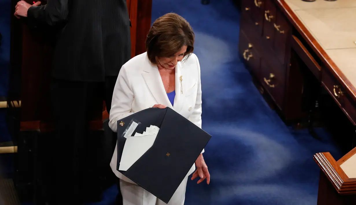 Ketua DPR Amerika Serikat Nancy Pelosi membawa naskah pidato kenegaraan Donald Trump yang dia sobek dalam Kongres di Capitol Hill, Washington, Selasa (4/2/2020). Menurut Pelosi, aksi itu merupakan hal yang sopan untuk dilakukan dibanding beberapa alternatif lainnya. (AP Photo/J. Scott Applewhite)