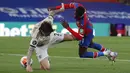 Bek Manchester United, Victor Lindelof, berebut bola dengan striker Crystal Palace, Wilfried Zaha, pada laga lanjutan Premier League di Selhurst Park, Jumat (17/7/2020) dini hari WIB. Manchester United menang 2-0 atas Crystal Palace. (AFP/Peter Cziborra/pool)