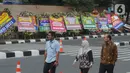 Pejalan kaki melintasi karangan bunga ucapan selamat yang berjejer di sekitar Gedung Merah Putih KPK, Jakarta, Jumat (20/12/2019). Papan karangan bunga tersebut berisi ucapan selamat terhadap dilantiknya pimpinan KPK periode 2019-2023. (merdeka.com/Imam Buhori)