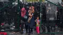 Imigran wanita dan anak-anak berhasil dievakuasi petugas dari bentrokan yang terjadi antara polisi dengan imigran yang berusaha menerobos pintu perbatasan Serbia dan Hungaria di Roszke, Rabu (16/9/2015). (REUTERS/Marko Djurica)