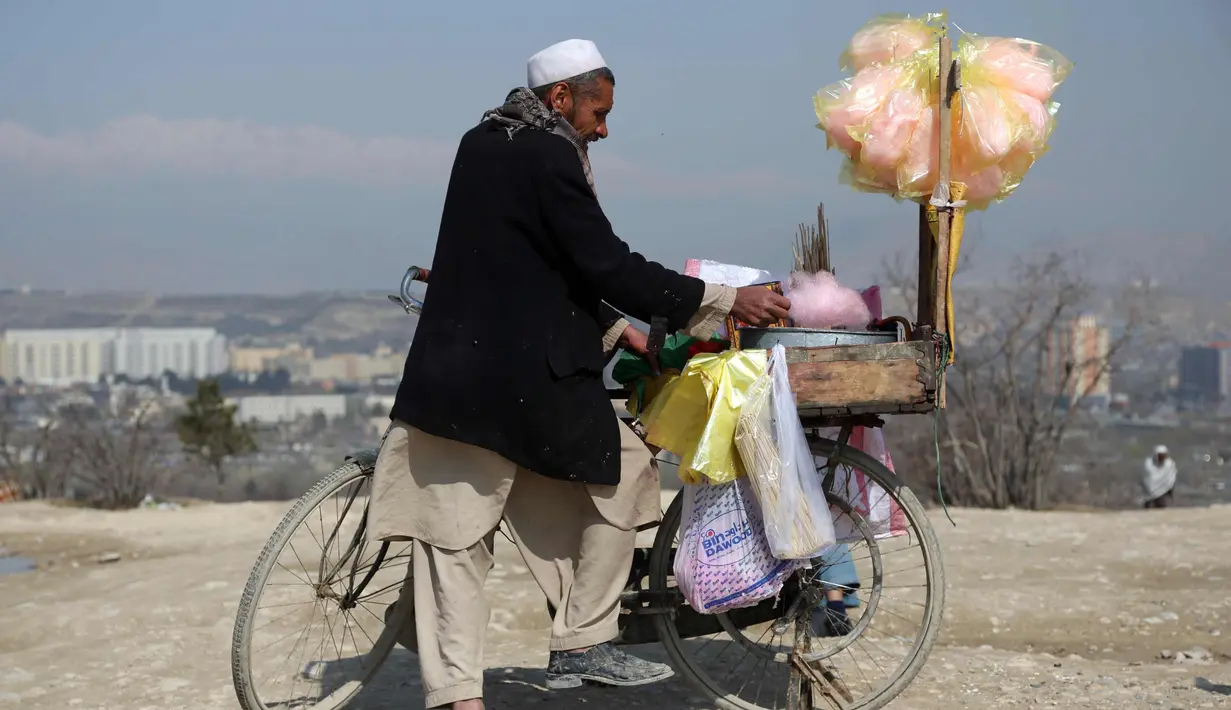 Seorang pedagang membuat gulali selama perayaan Nowruz, Tahun Baru Persia, di Kabul, Afghanistan, (21/3). Nowruz dirayakan pada hari pertama musim semi di negara-negara termasuk Afghanistan, Tajikistan, dan Iran. (AP Photo/Rahmat Gul)