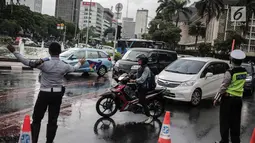 Polisi dan petugas Dishub mengalihakan arus lalu lintas terkait Malam Munajat 212 di Medan Merdeka Barat dan Utara, Jakarta, Kamis (21/2). Masyarakat yang akan melintasi kawasan Monas diharapkan mencari jalur alternatif. (Liputan6.com/Faizal Fanani)