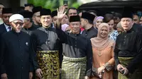 Muhyiddin Yassin (tengah) melambaikan tangan sebelum upacara pelantikannya sebagai Perdana Menteri Malaysia di Istana Negara, Kuala Lumpur, Minggu (1/3/2020). Berdasarkan hukum Malaysia, penunjukan PM Malaysia bisa dilakukan oleh raja. (NAZRI RAPAAI/AFP/MALAYSIA'S DEPARTMENT OF INFORMATION)