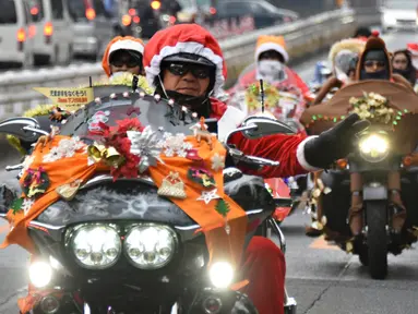 Sejumlah pengendara motor gede mengenakan kostum Santa Claus dan rusa di kota Tokyo, Jepang, (23/12). Touring ini dinamakan "Toy Run" yang diselenggarakan oleh komunitas Harley Santa Club. (AFP PHOTO/Toru Yamanaka)