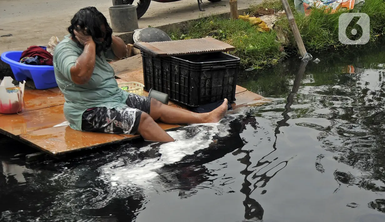 Warga mandi di Kali Cilemahabang yang menghitam di kawasan Karangbahagia, Kabupaten Bekasi, Jawa Barat, Selasa (7/9/2021). Warga memanfaatkan aliran Kali Cilemahabang yang menghitam dan mengeluarkan bau tak sedap untuk mencuci baju hingga mandi. (Liputan6.com/ Herman Zakharia)