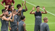 Pemain Arsenal, Mesut Ozil (kanan) menjalani sesi latihan untuk kompetisi pramusim International Champions Cup (ICC) 2018 di Singapura, Rabu (27/5). Menjelang duel kontra Atletico Madrid, Ozil dkk menikmati sesi latihan ringan. (AFP/Roslan RAHMAN)