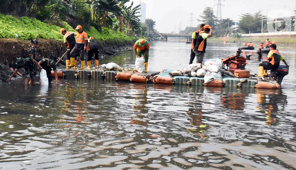Personel gabungan mengumpulkan sampah dalam karung saat kegiatan Grebeg Kali Ciliwung. (Liputan6.com/Herman Zakharia)